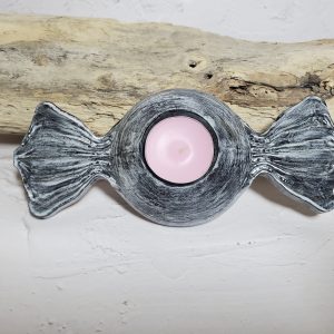 Bougeoir en céramique en forme de bonbon, avec des couleurs pastel et un design gourmand, parfait pour créer une ambiance chaleureuse et ludique.