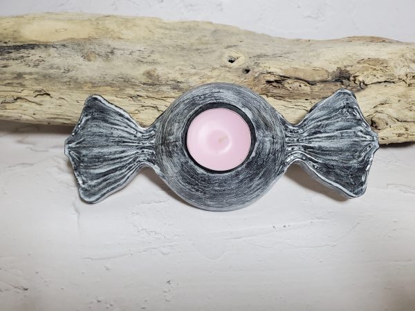Bougeoir en céramique en forme de bonbon, avec des couleurs pastel et un design gourmand, parfait pour créer une ambiance chaleureuse et ludique.