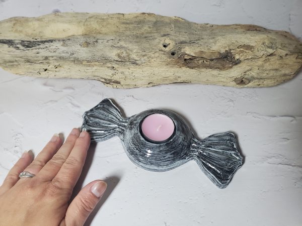 Bougeoir en céramique en forme de bonbon, avec des couleurs pastel et un design gourmand, parfait pour créer une ambiance chaleureuse et ludique.