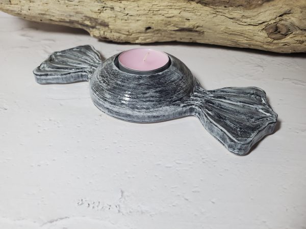 Bougeoir en céramique en forme de bonbon, avec des couleurs pastel et un design gourmand, parfait pour créer une ambiance chaleureuse et ludique.