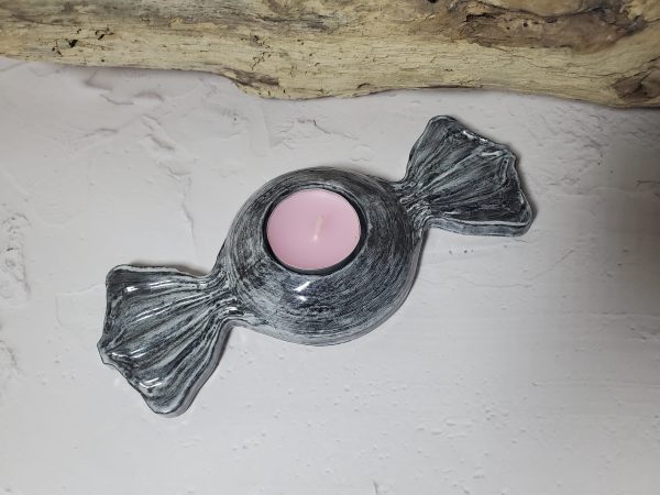 Bougeoir en céramique en forme de bonbon, avec des couleurs pastel et un design gourmand, parfait pour créer une ambiance chaleureuse et ludique.