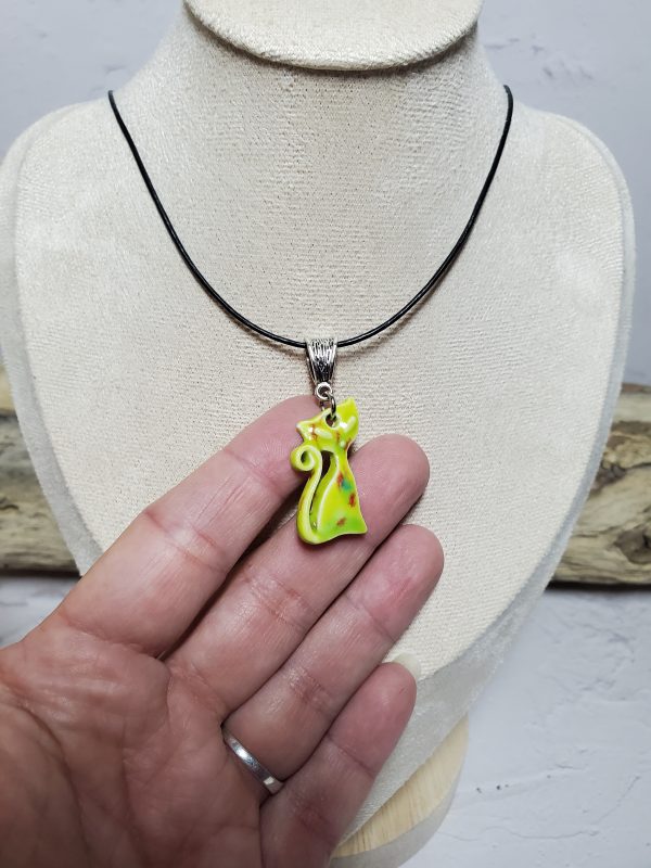 Pendentif en céramique représentant un chat élégant, avec des détails raffinés et une finition lisse, parfait pour les amoureux des félins et les collectionneurs de bijoux uniques.