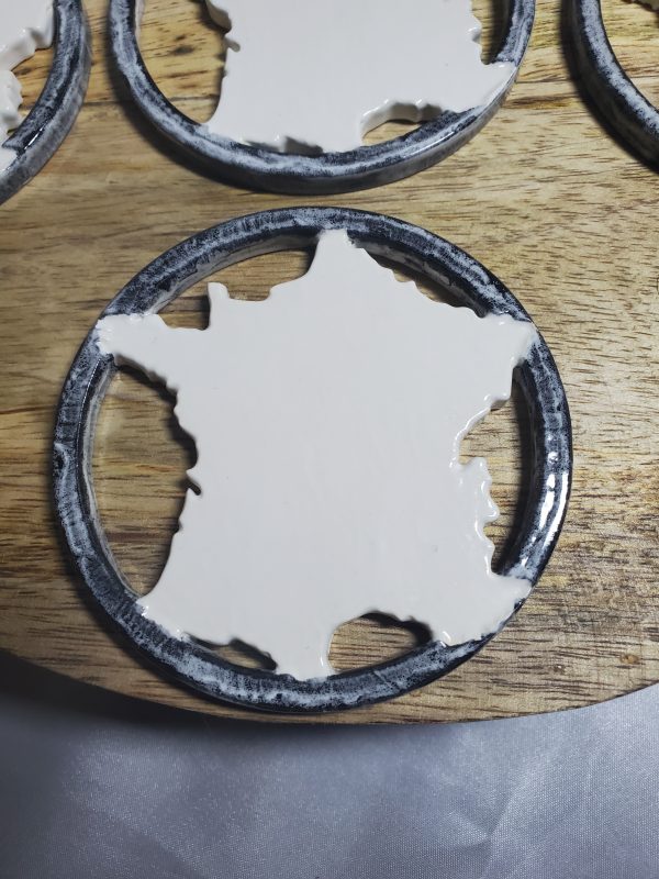 Sous-verres en céramique artisanaux représentant la carte de France, élégants et uniques, parfaits pour une décoration raffinée et pratique.