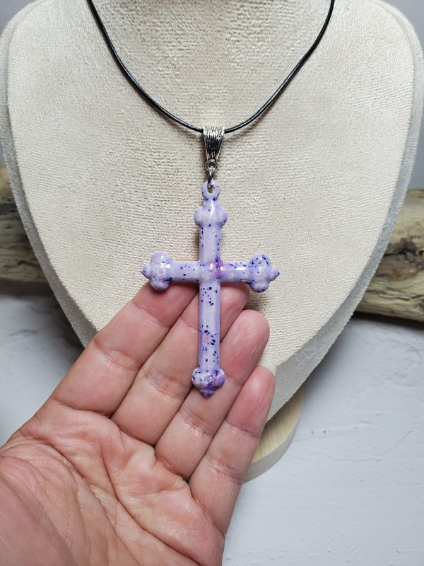 Pendentif artisanal en céramique en forme de croix, conçu avec élégance et soin, symbole de spiritualité et de raffinement.