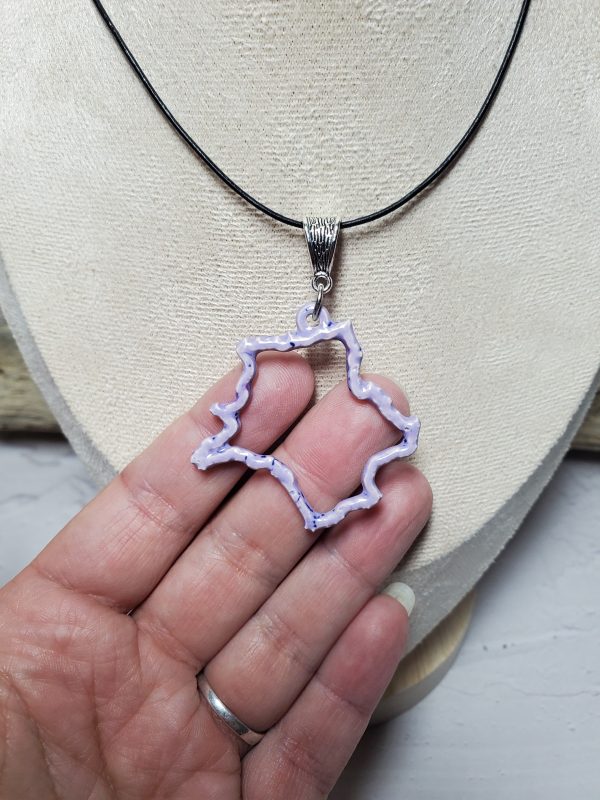 Pendentif artisanal en céramique représentant la carte de France, bijou unique et élégant, parfait pour les amoureux de l'artisanat français.
