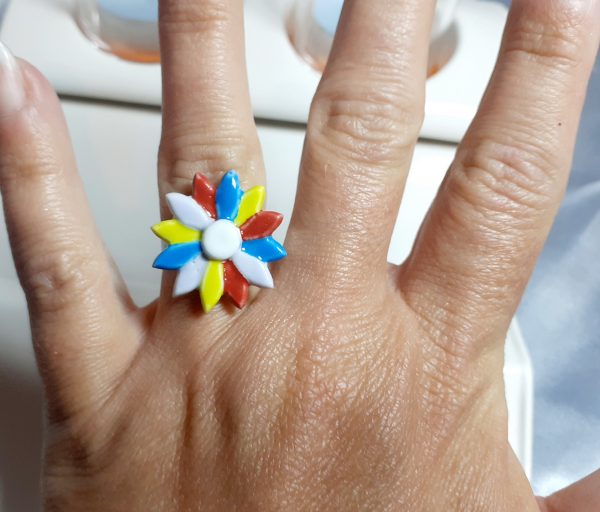 Bague artisanale en céramique ornée d'une fleur multicolore, idéale pour un style éclatant et unique.