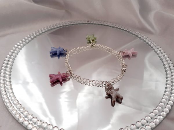 Bracelet artisanal avec figurines en céramique en forme de petits bonhommes, idéal pour un style original et ludique.
