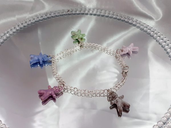 Bracelet artisanal avec figurines en céramique en forme de petits bonhommes, idéal pour un style original et ludique.