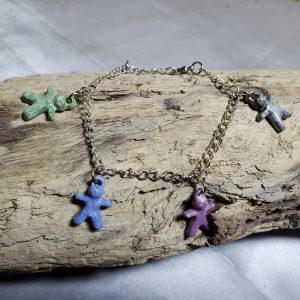 Bracelet artisanal avec figurines en céramique en forme de petits bonhommes, idéal pour un style original et ludique.