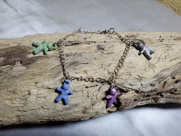 Bracelet artisanal avec figurines en céramique en forme de petits bonhommes, idéal pour un style original et ludique.