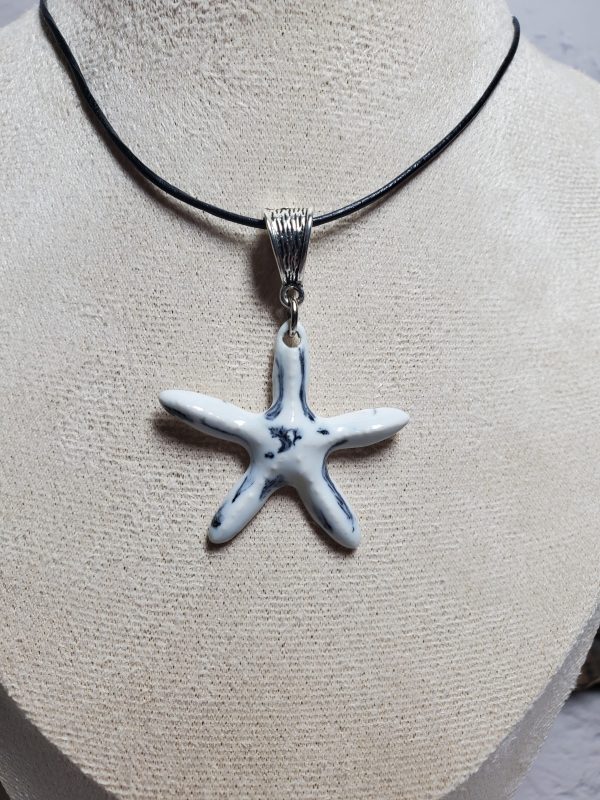 Pendentif en céramique en forme d'étoile de mer, fait main, élégant et unique, parfait pour offrir ou compléter une tenue estivale. Disponible sur Only Ceramic Creation.