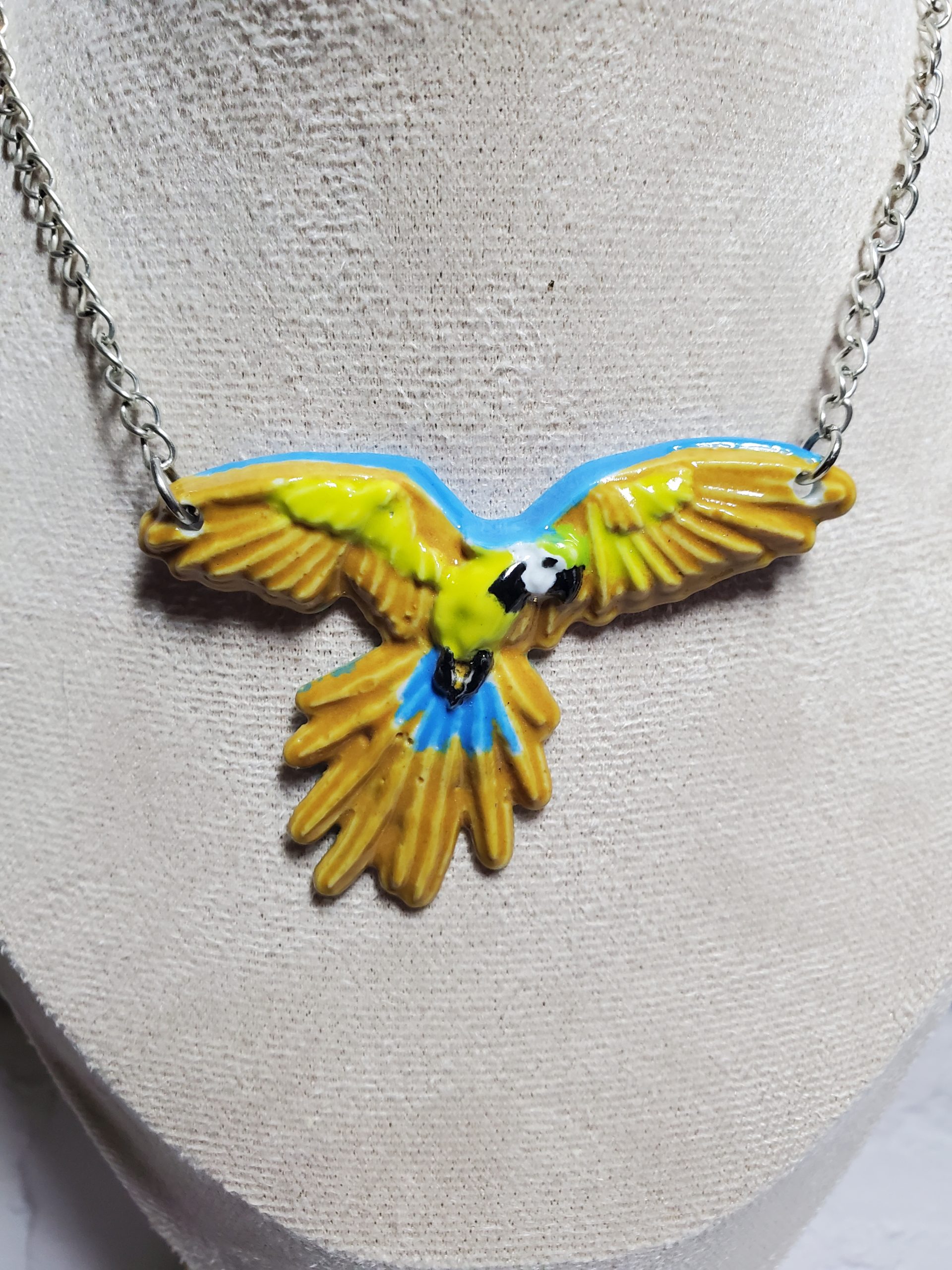 Pendentif perroquet en céramique, accessoire exotique et raffiné.