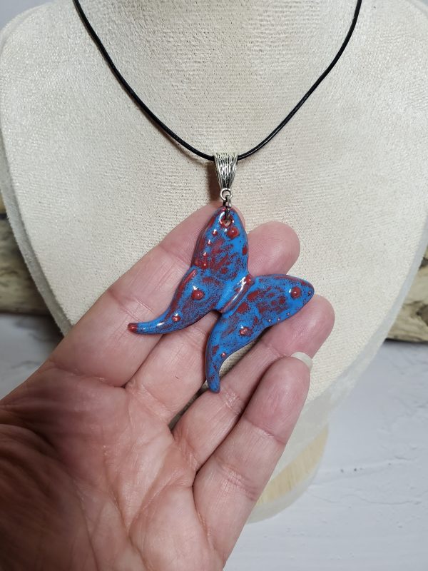 Pendentif délicat en céramique en forme de papillon, fait main avec un design élégant et naturel. Accessoire unique idéal pour compléter une tenue sophistiquée.