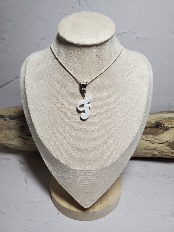 Pendentif artisanal en céramique avec initiale F, bijou élégant et unique.