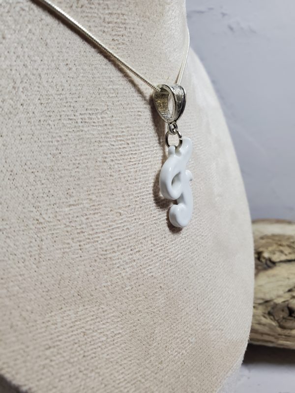 Pendentif artisanal en céramique avec initiale F, bijou élégant et unique.