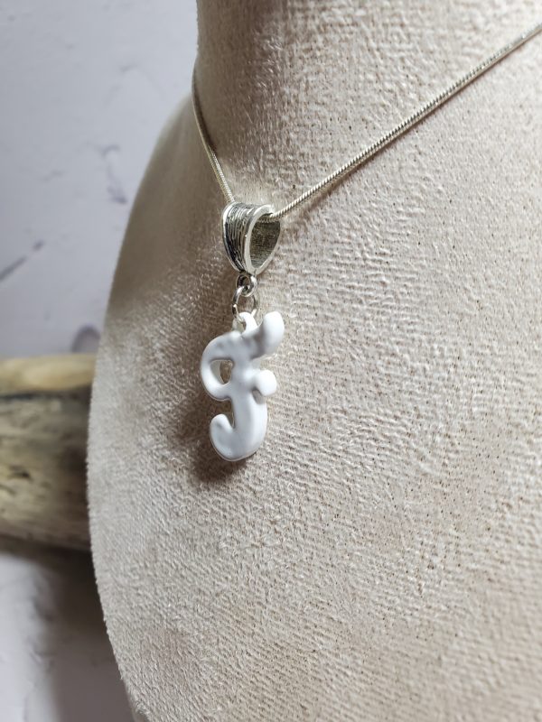 Pendentif artisanal en céramique avec initiale F, bijou élégant et unique.