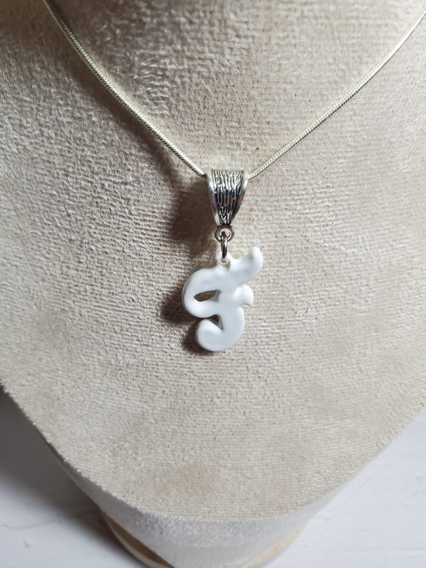 Pendentif artisanal en céramique avec initiale F, bijou élégant et unique.