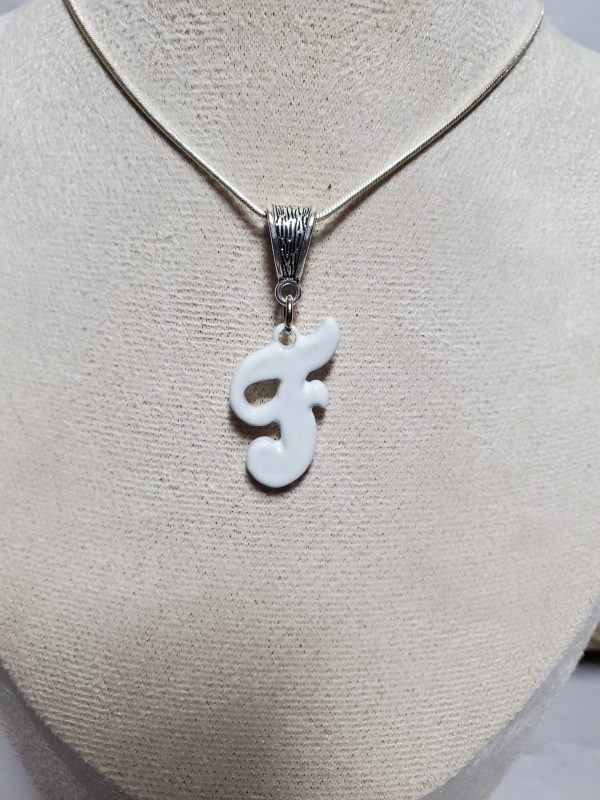 Pendentif artisanal en céramique avec initiale F, bijou élégant et unique.