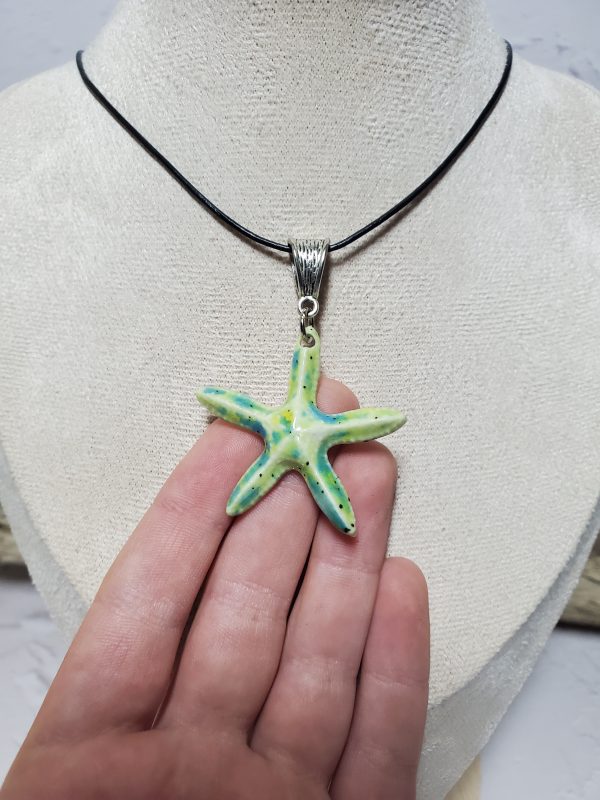 Pendentif artisanal en céramique en forme d'étoile de mer, élégant et unique, parfait pour ajouter une touche marine à votre style.