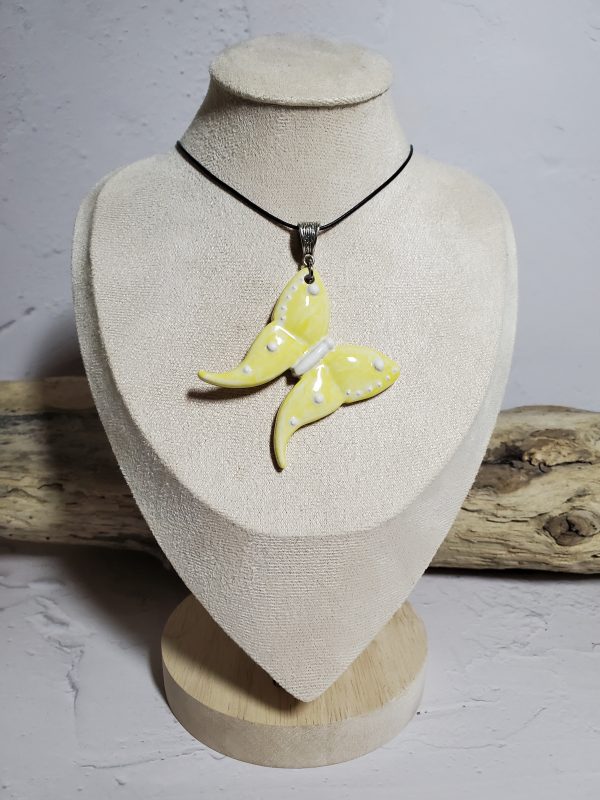 Un pendentif artisanal en céramique représentant un papillon, symbole d'élégance et de légèreté. Parfait pour ajouter une touche de nature et de raffinement à vos tenues.