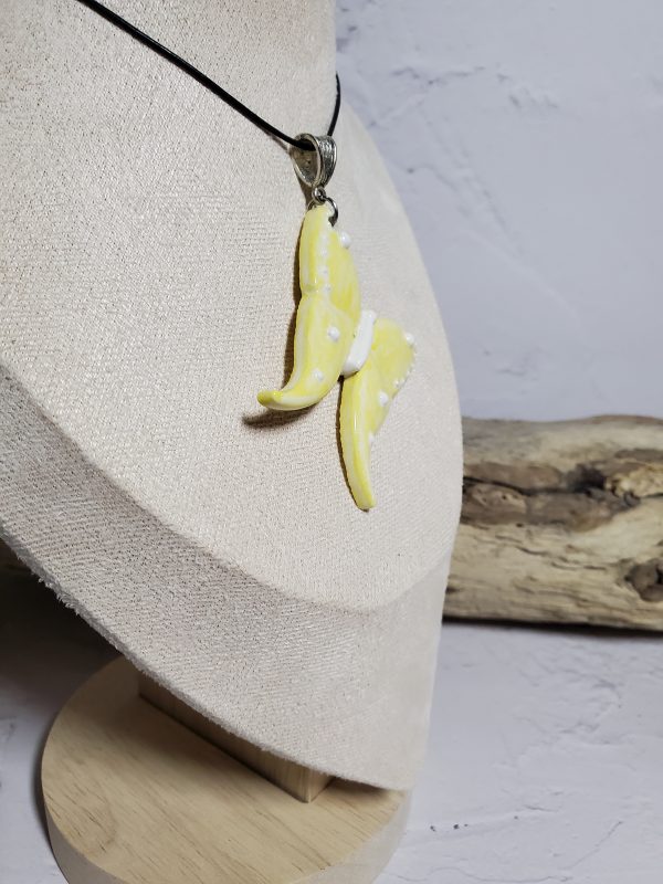 Un pendentif artisanal en céramique représentant un papillon, symbole d'élégance et de légèreté. Parfait pour ajouter une touche de nature et de raffinement à vos tenues.