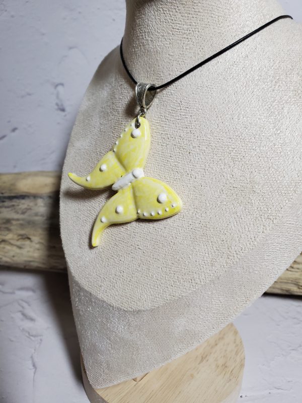 Un pendentif artisanal en céramique représentant un papillon, symbole d'élégance et de légèreté. Parfait pour ajouter une touche de nature et de raffinement à vos tenues.