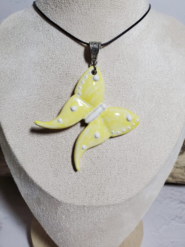 Un pendentif artisanal en céramique représentant un papillon, symbole d'élégance et de légèreté. Parfait pour ajouter une touche de nature et de raffinement à vos tenues.