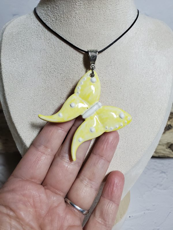Un pendentif artisanal en céramique représentant un papillon, symbole d'élégance et de légèreté. Parfait pour ajouter une touche de nature et de raffinement à vos tenues.