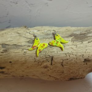 Élégantes boucles d'oreilles en céramique façonnées en forme de papillon, avec des détails délicats et une finition brillante qui reflète la lumière avec douceur.